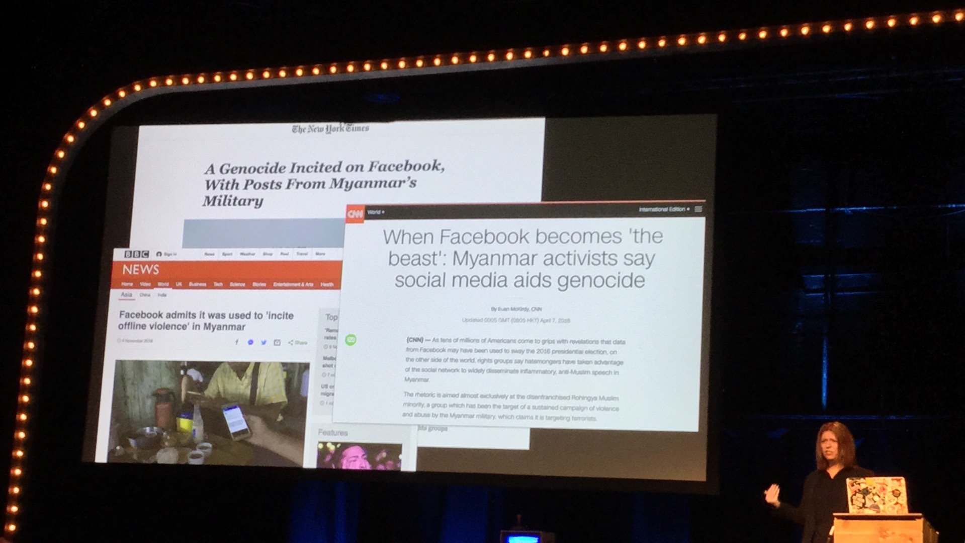 Charlie Owen presenting at Beyond Tellerand, showing screenshots of news reporting Facebook enabling physica harm